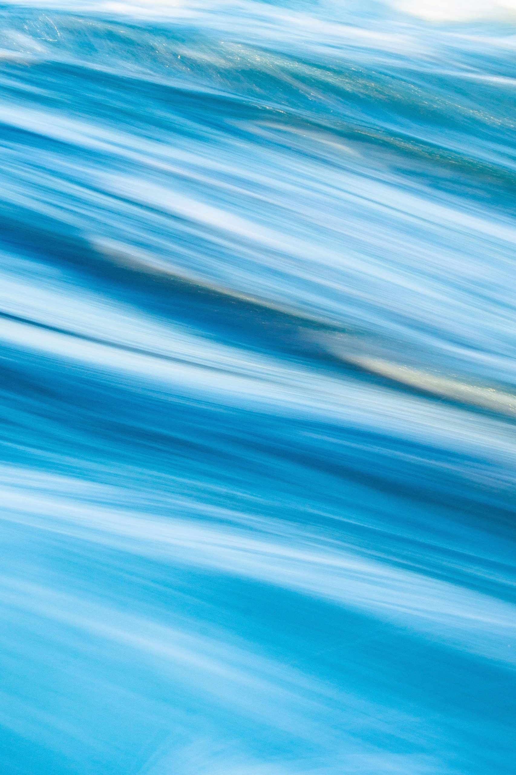 Vibrant abstract motion blur with shades of blue creating a dynamic texture.